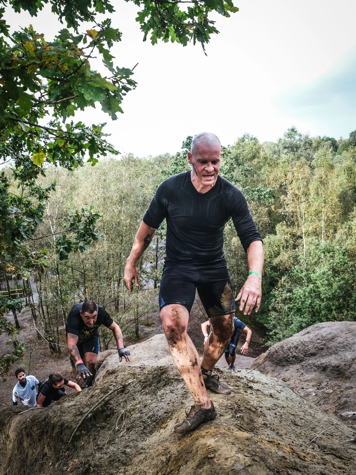 Bjorn climbing a steep muddy obstacle