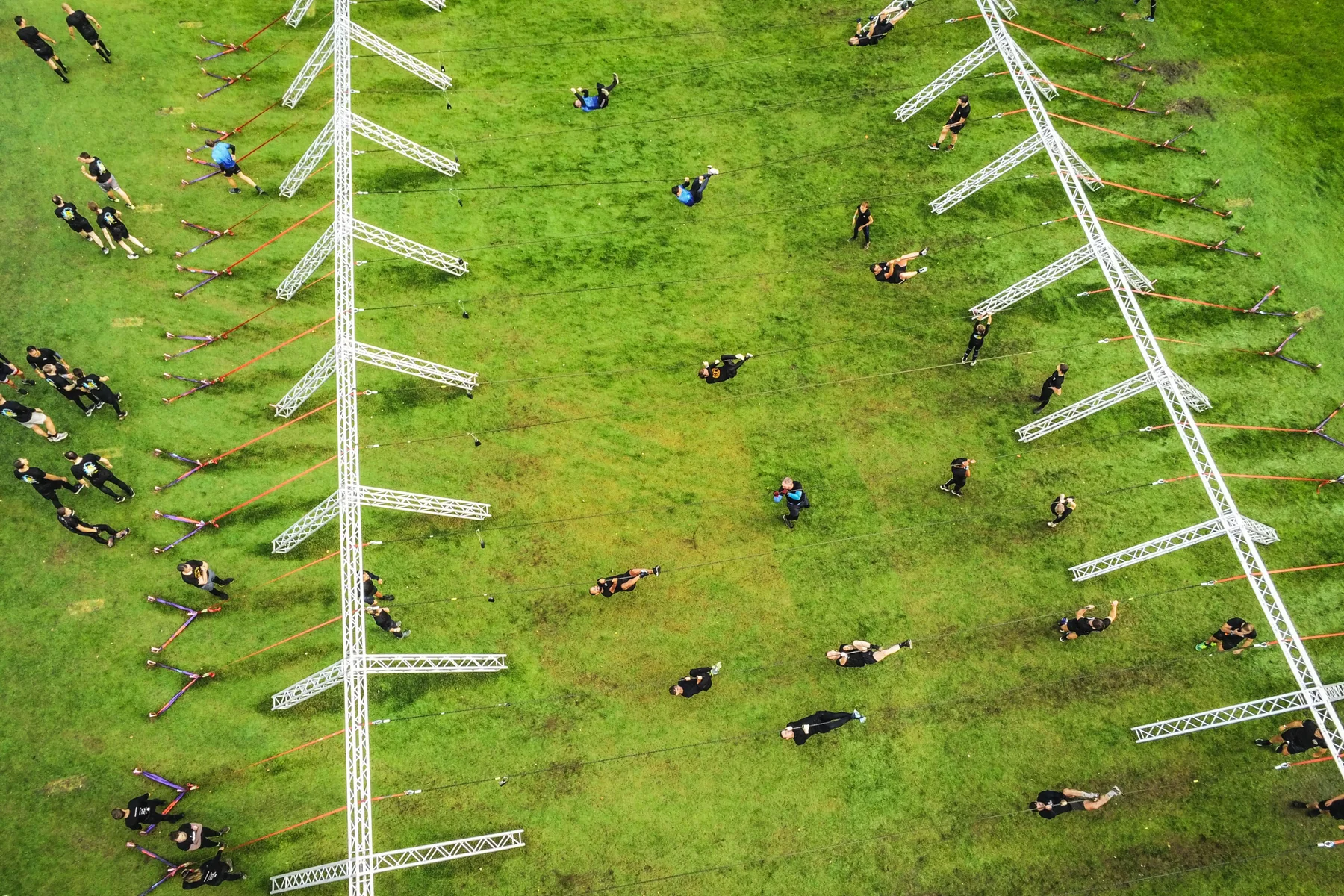 Aerial view of runners moving below the powerlines on the Spartacus course